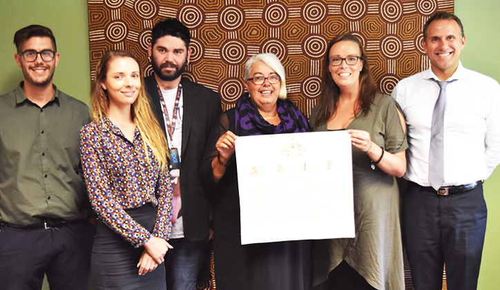  Associate Professor Shane Hearn, Director of Indigenous Strategy (far right) and Walanga Muru staff members, pictured with a copy of the National Apology to the Stolen Generation owned by Cultural Adviser, Sue Pinckham.