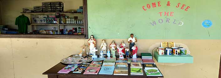 A table with religious pamphlets and statues outside a shop