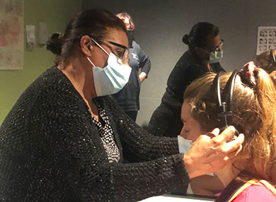 Researchers putting on headphones to people in a lab