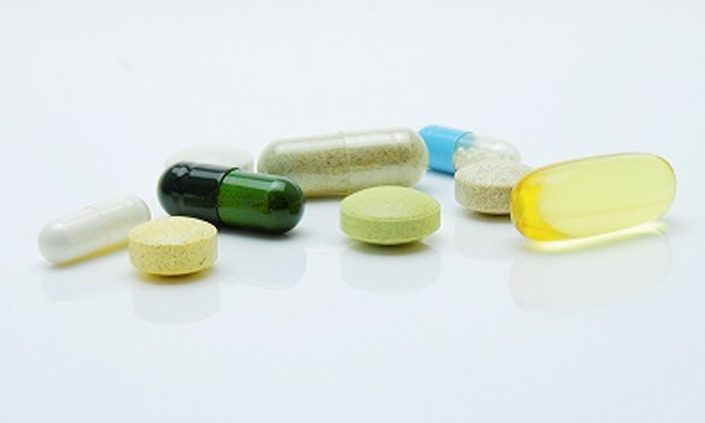 Different pills of colour and shape on a white background.