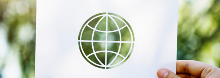 A hand holding up a piece of paper with a cutout of a circular "innovation" symbol.