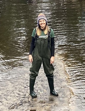 Dr Meagher wearing waders, standing in a stream.