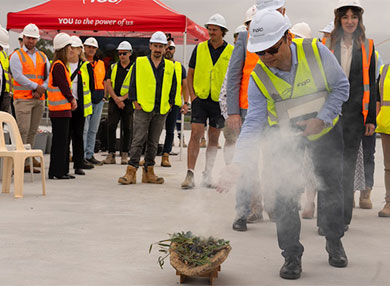 Man in High-vis and hard hat performing smoking ceremony