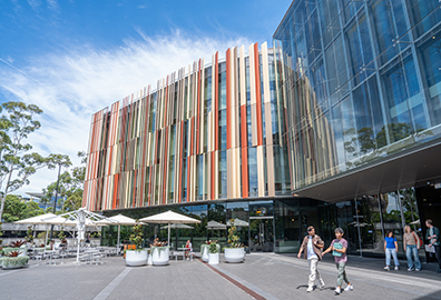 The outside of the library building with students walking out from it