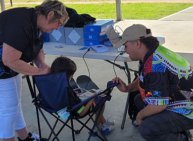 Two technicians doing a hearing test on a child