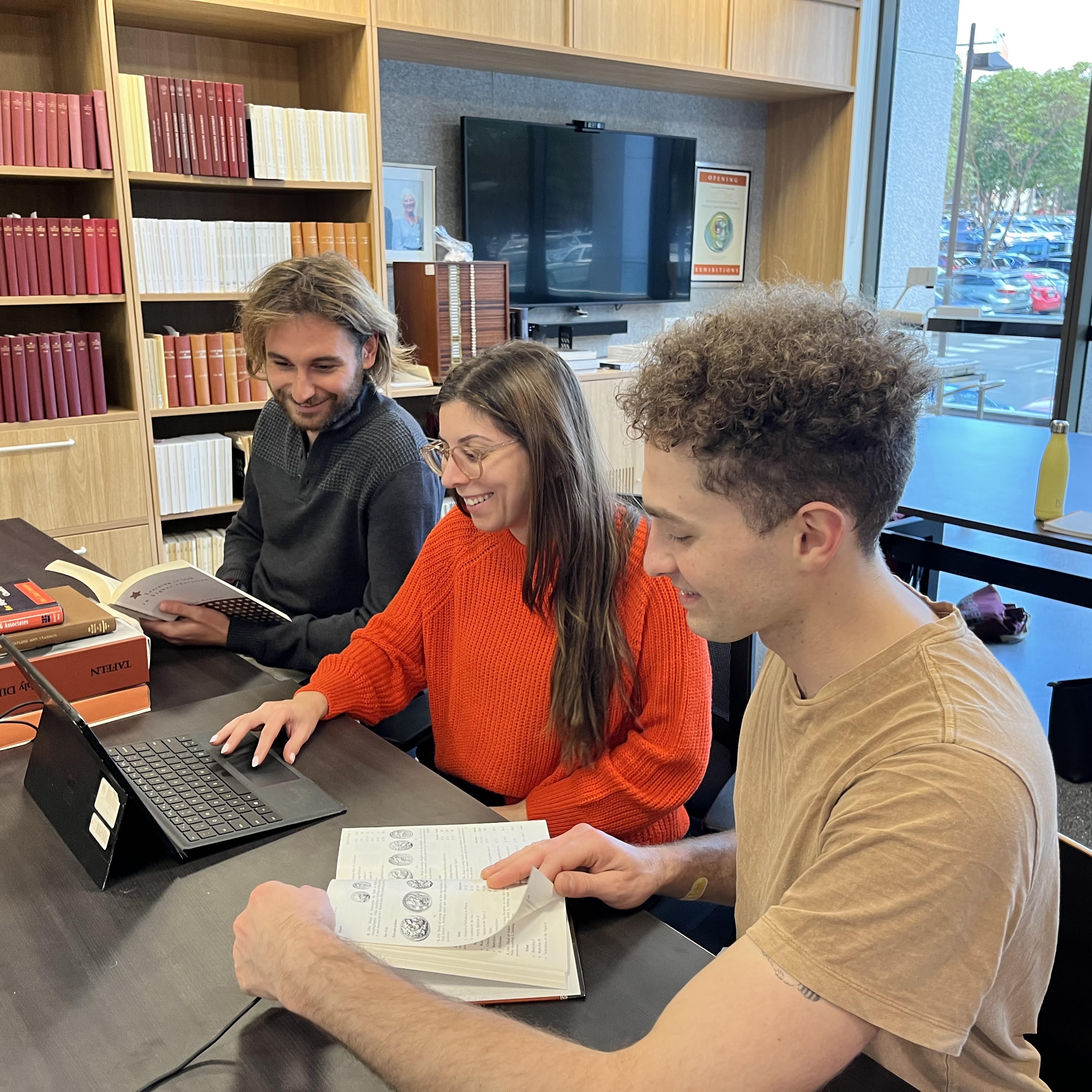 Three people looking at a laptop