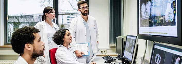 Four researchers looking at images on screens