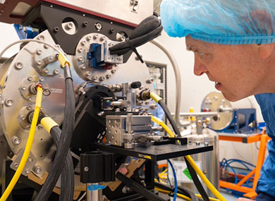 Man in hairnet closely inspecting DIRAC instrument