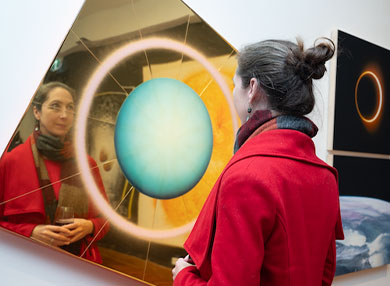 Person standing in front of reflective golden artwork