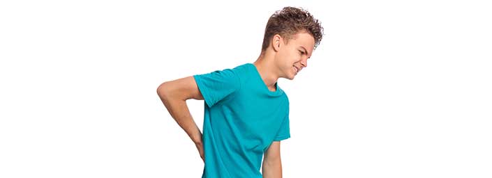 An image of a teenage boy holding is back in pain