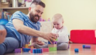 Dad and infant stacking blocks