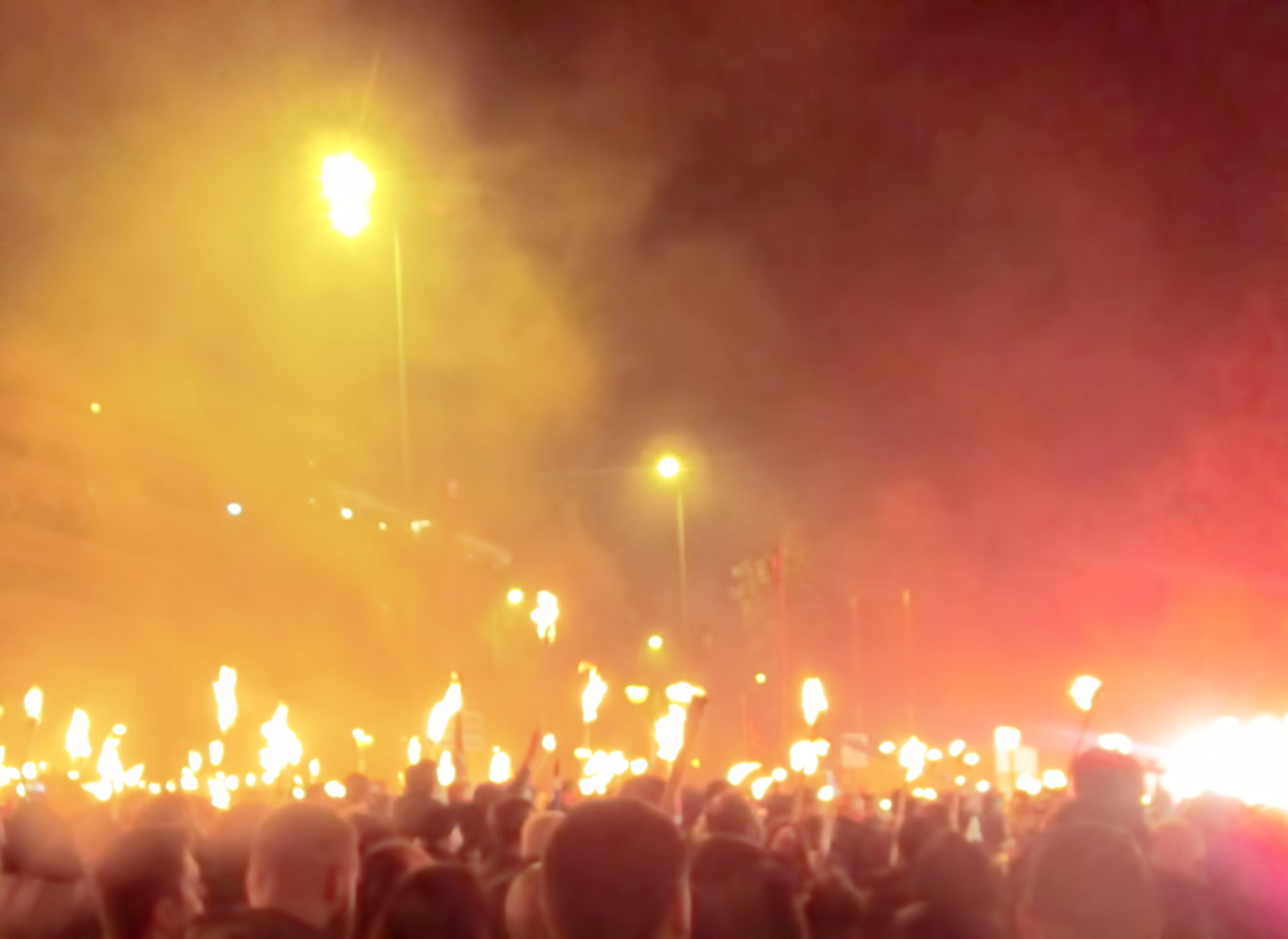 A crowd of anti-fascist protestors holding torches.
