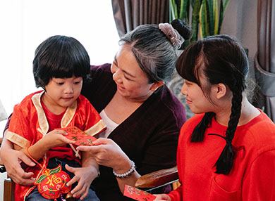 Two children smiling with an older carer.