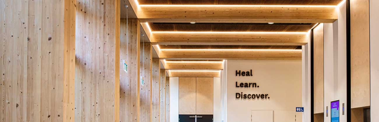 Inside the faculty building with the words Heal. Learn. Discover. written on the wall
