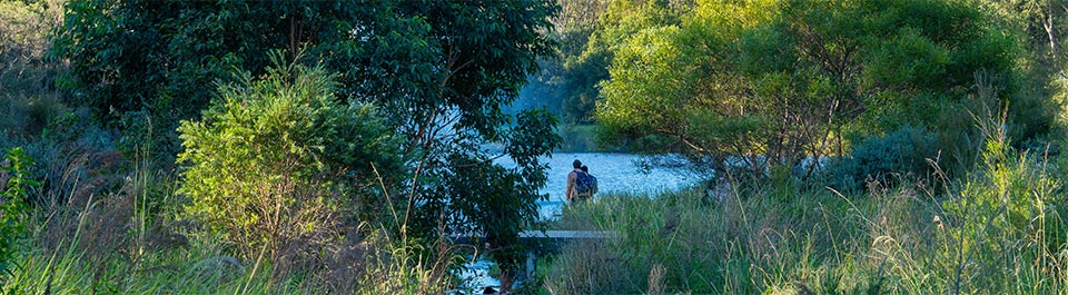 2 people standing at a lake