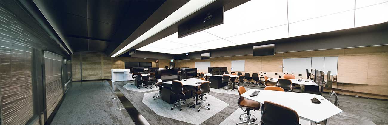 Business room full of computer monitors, TVs and desks