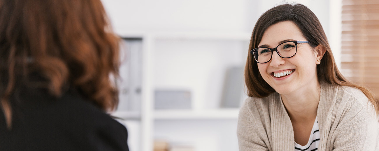 Teacher smiling and chatting to a student