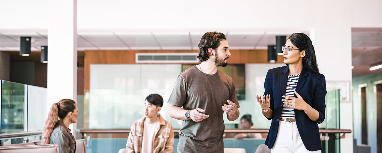 A lecturer and student discussing things in a classroom
