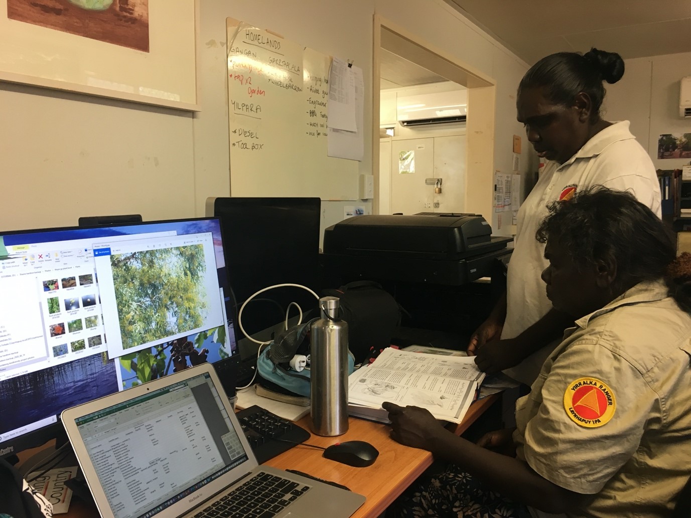 Yirralka Rangers Nyemburr Munungurr and Djurrayum Murrunyina at computer desk reading book