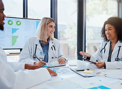 A team of three doctors in discussion during a work meeting