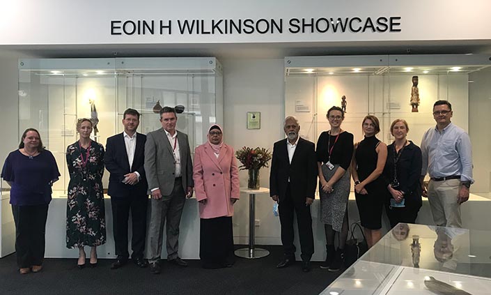 Group of people standing in front of a sign that reads Eoin H Wilkinson Showcase