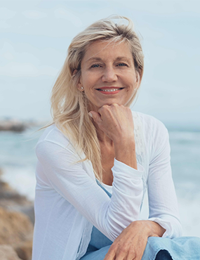 Woman sitting at beach smiling