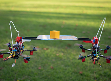 Two drones hovering with a tray balanced between them.
