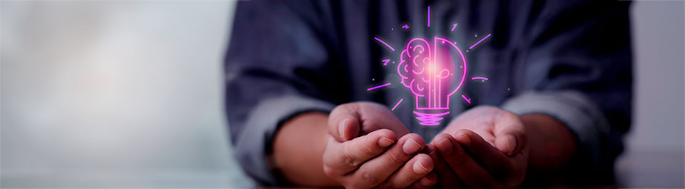 A person with cupped hands holding an animation of a lightbulb combined with a brain