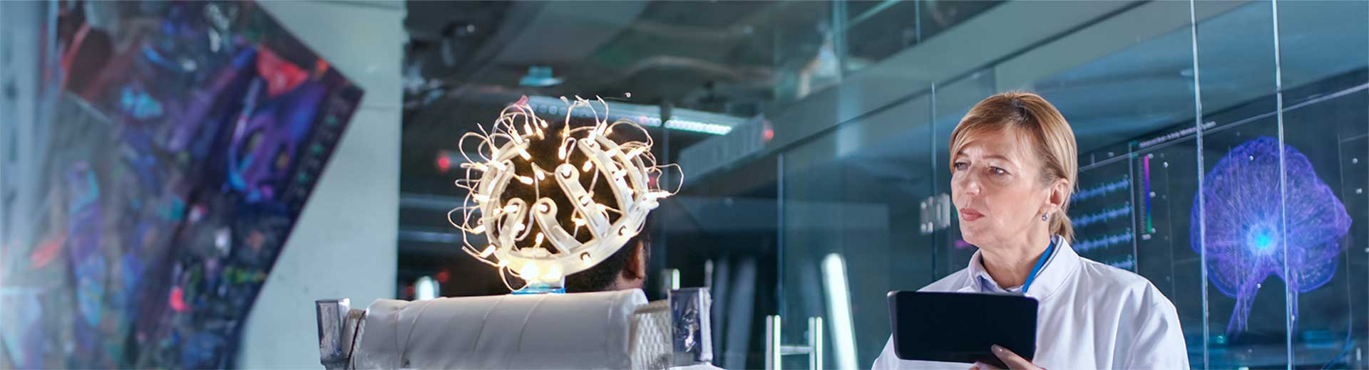 A researcher in a lab conducting an experiment on a person wearing a brain monitor