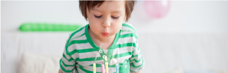 child blowing out candle