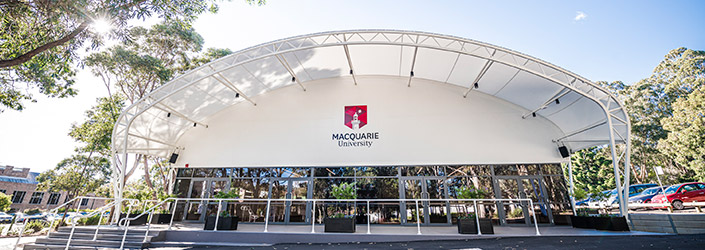 Front entrance of a large steel supported white marquee.