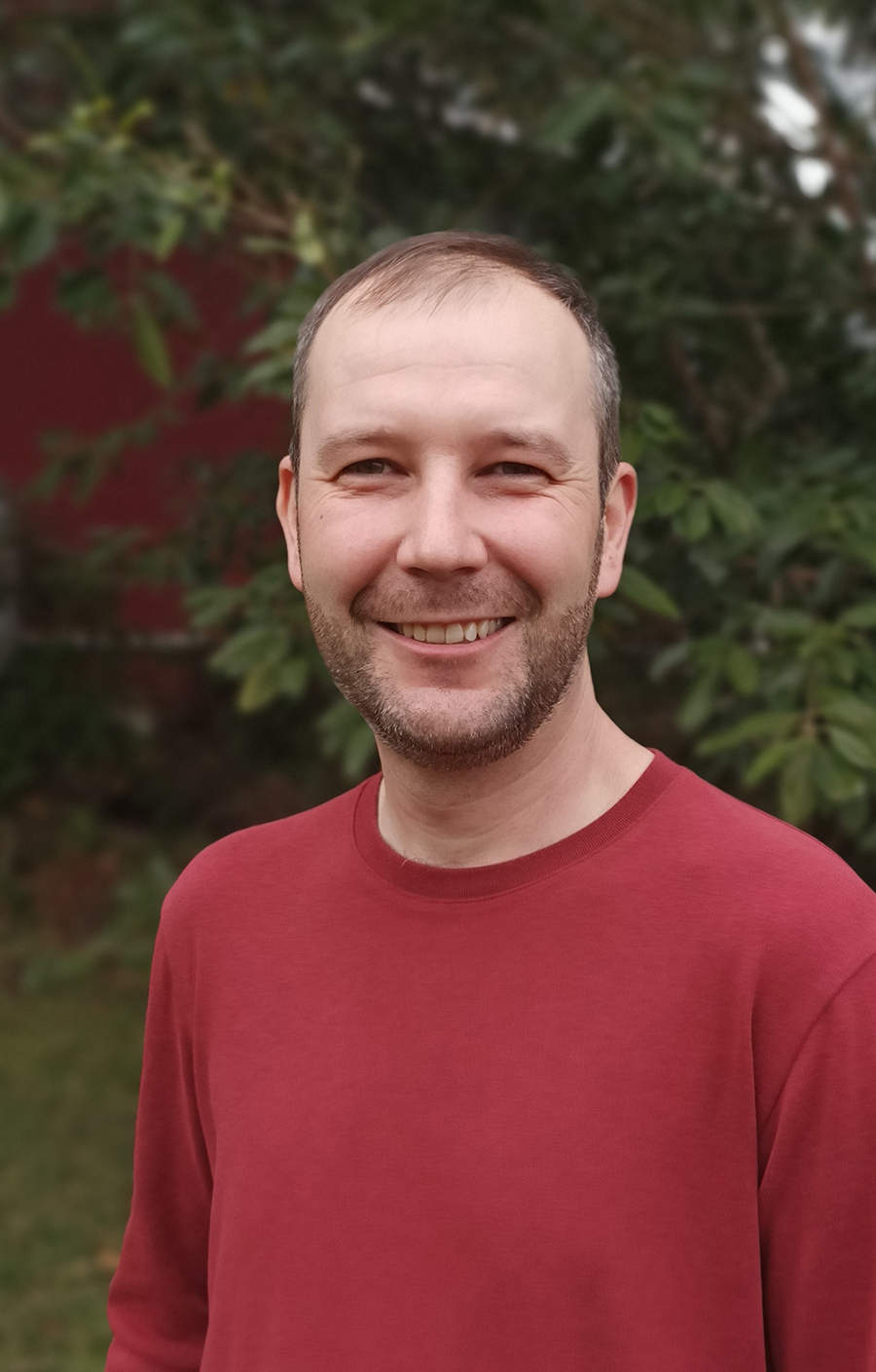 Portrait photo of Dr Michael Spate standing outside in front of trees