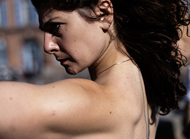 A close-up shot of Coline facing the left with her arms extended.