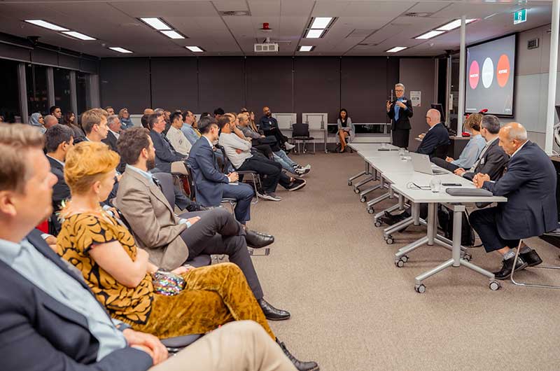 People-sitting-in-a-room-listening-to-a-woman-present