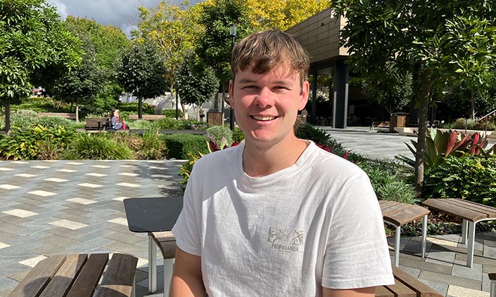 Bailey sitting at campus smiling