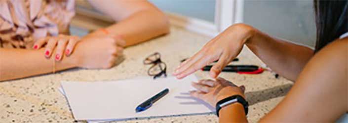 Two students sitting at a table talking