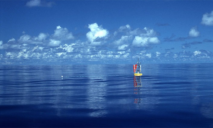 Science buoy floating in the ocean with cloudy horizon