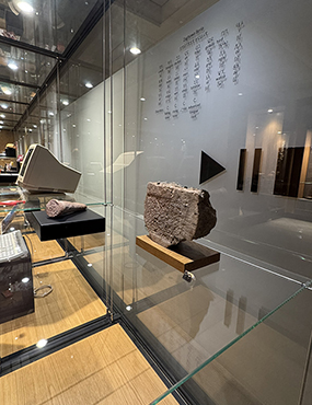 Ancient brick inscribed with Babylonian cuneiform and a modern computer console
