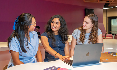 Three students studying together on campus.