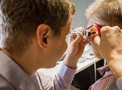 A doctor giving an ear exam with an otoscope.
