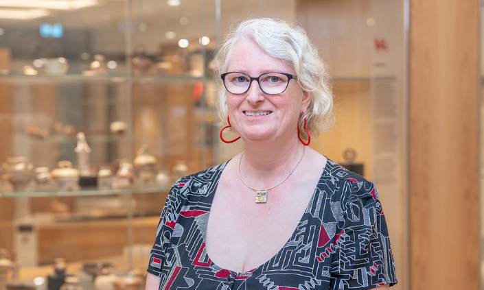 Woman smiling at camera with museum objects in the background