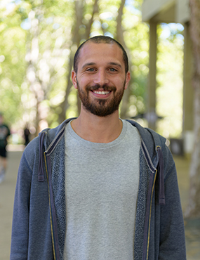 Tim Ghaly, a 2019 University medallist wearing a grey t-shirt and an unzipped hooded jacket.