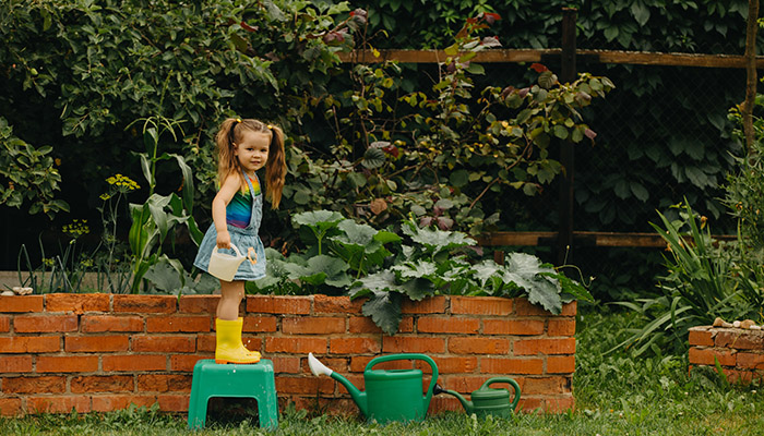 Girl standing on garden wall