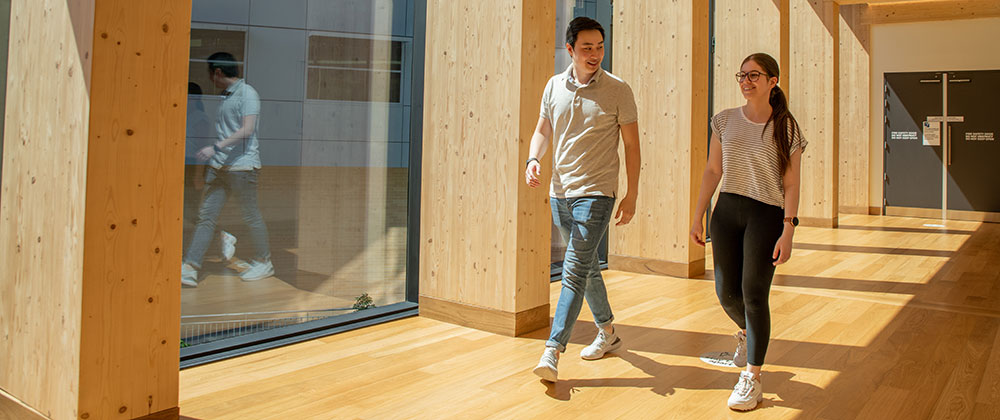 Two students walking down the hall in the faculty building