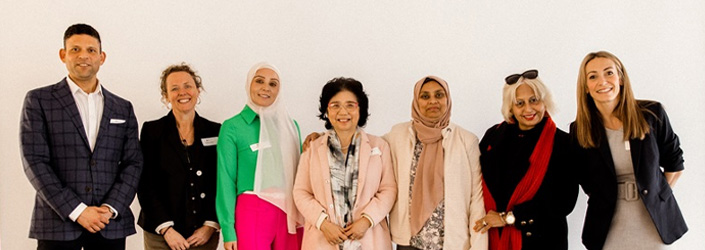 A group of seven professionals standing and smiling at the camera.