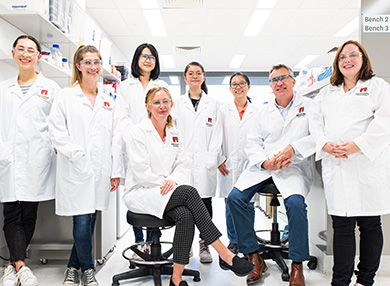 A group of MND researchers in white lab coats