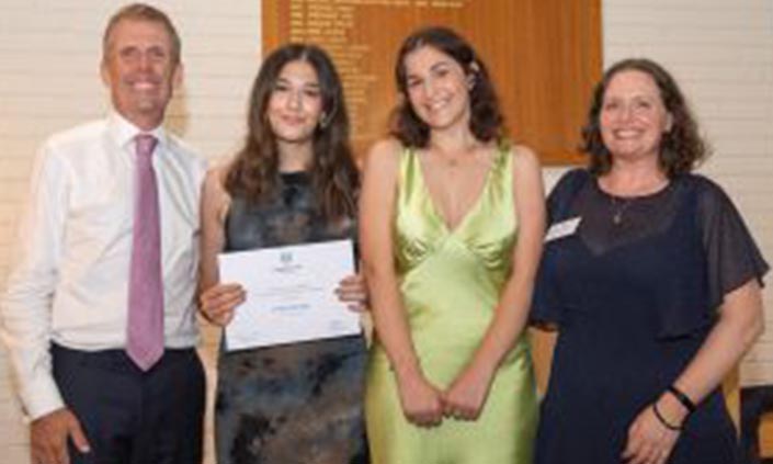 Pria holding certificate standing next to three other people