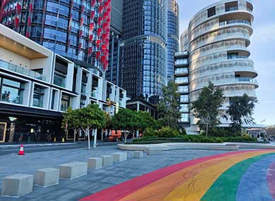 Apartment building along a pedestrian walkway with a rainbow painted on it