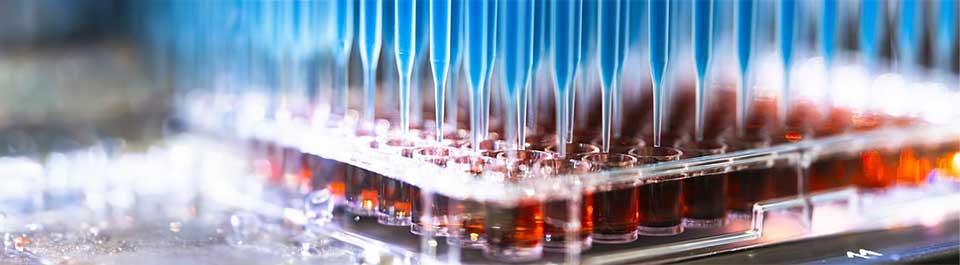 A tray of samples with droppers putting liquid into the bottles
