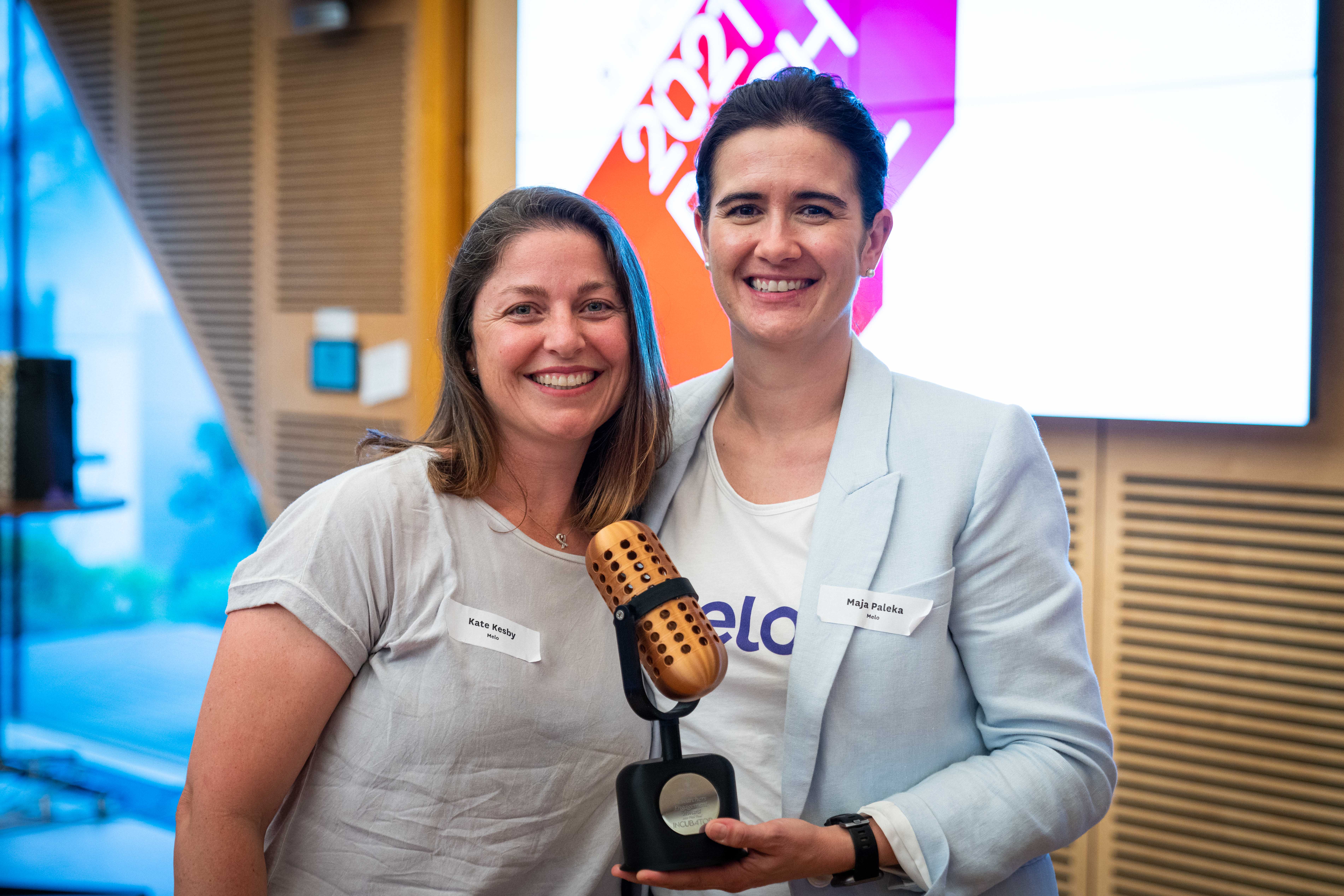 Two people holding awards